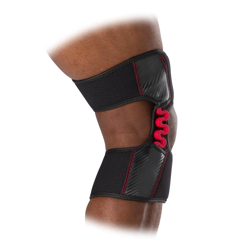 Nahaufnahme eines Knies mit schwarzer McDavid NRG Knee Over Wrap Bandage und rotem Federscharnier.