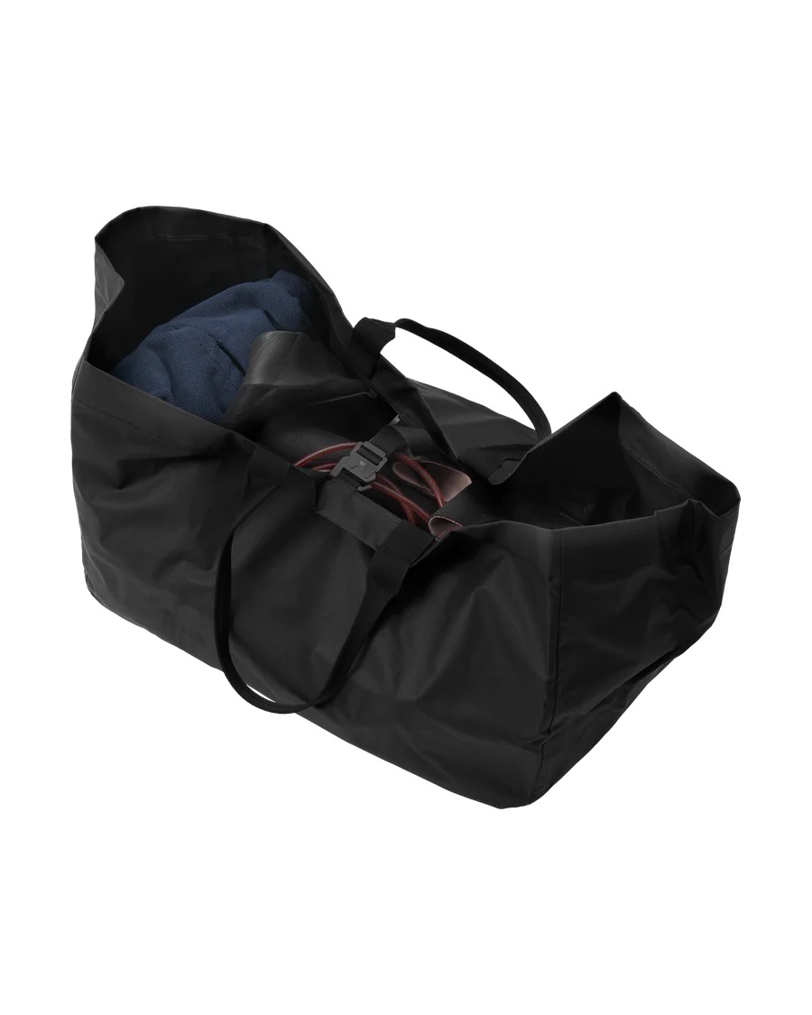 Schwarze Surf Tote 80L Offene, schwarze Douchebags Surf Essential Tote 80L Tasche mit Tragegriffen, gefüllt mit Kleidung.