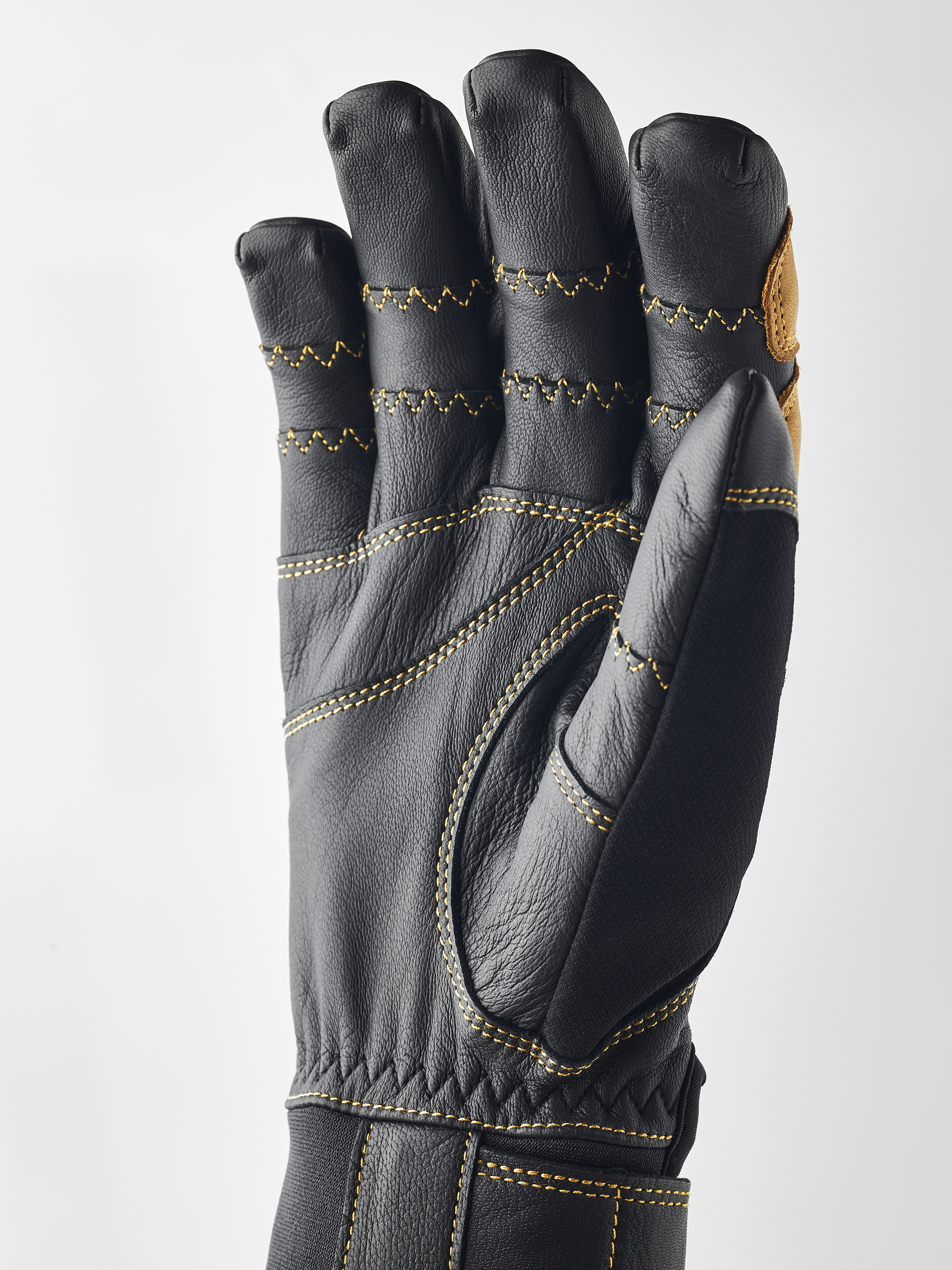 Schwarzer Hestra Ergo Grip Active Handschuh, Handfläche nach vorn, gelbe Nähte.