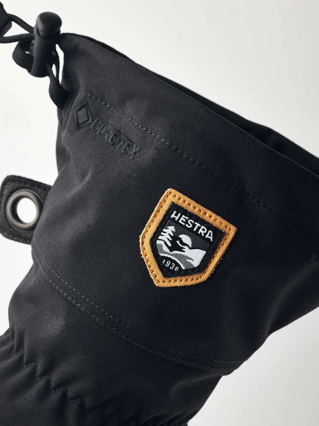 Detailansicht eines schwarzen Hestra-Handschuhs mit Gore-Tex und einem Hestra-Logo-Patch mit dem Schriftzug "1936".