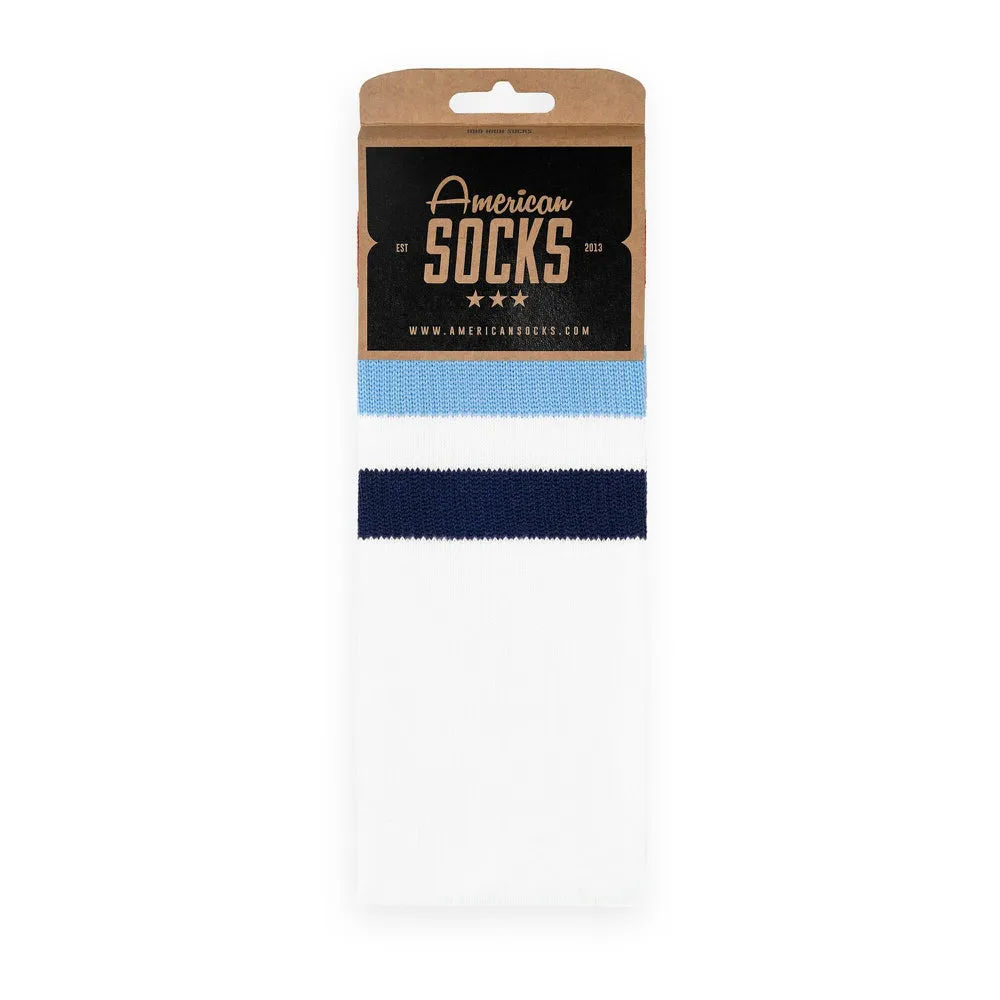 Verpackte, weiße Mid High Socken mit hellblauen und dunkelblauen Streifen.