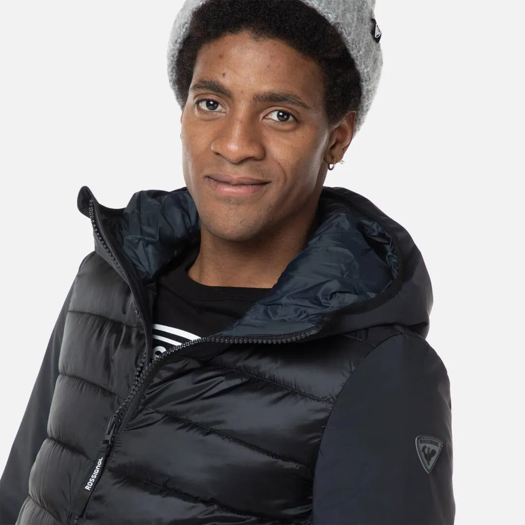 Mann mit Mütze trägt Rossignol Stretch Quilt Hoodie JKT in Schwarz.
