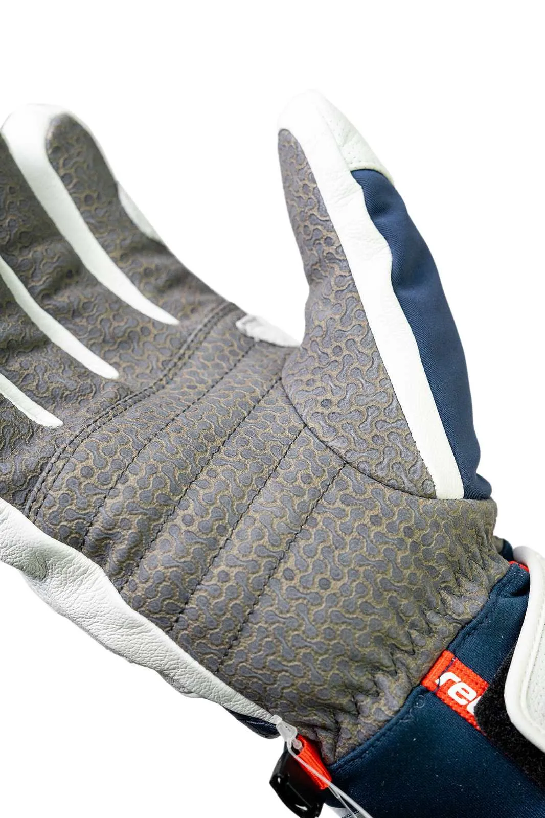 Nahaufnahme eines Handschuhs mit grauer Handfläche, weißen Streifen an den Fingern und marineblauem Gewebe.