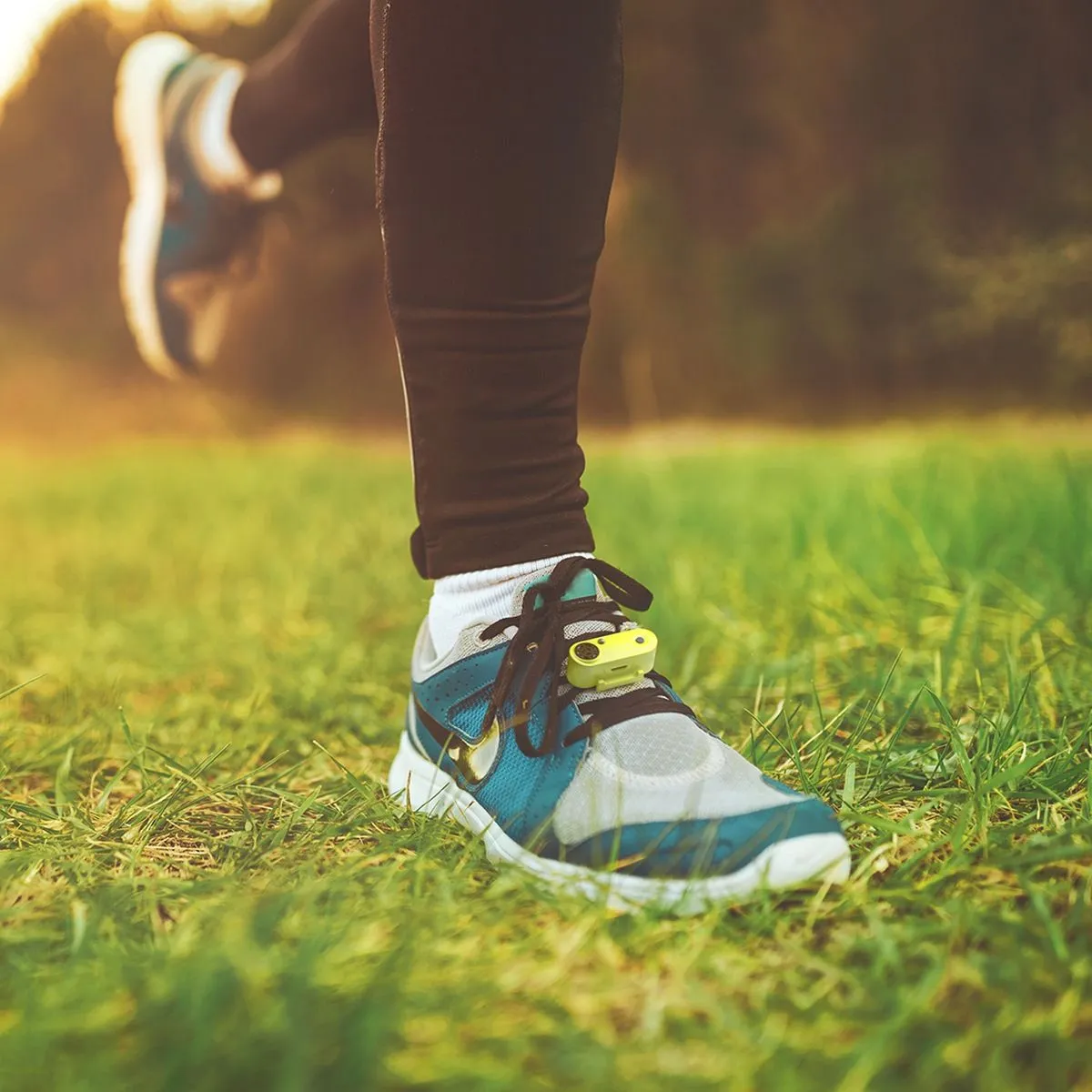 Läufer mit Tickless Run am Schuh, im Gras. Schutzgerät gegen Zecken für den Laufschuh.