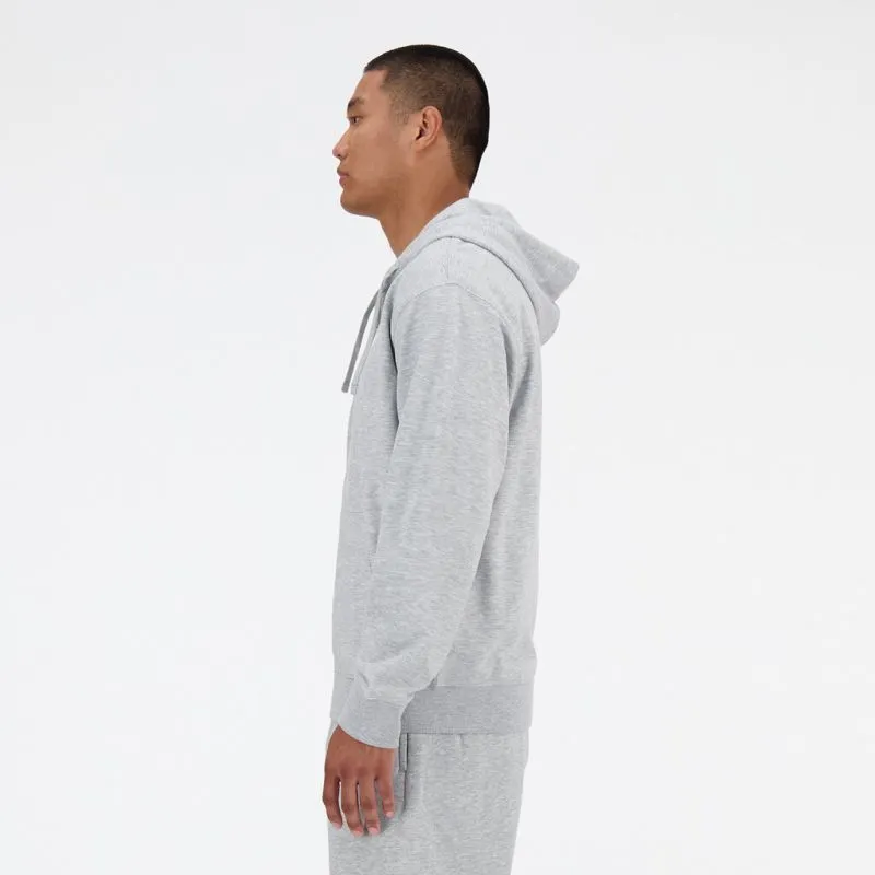 Ein Mann mit grauem New Balance Kapuzenpullover, seitliche Ansicht.