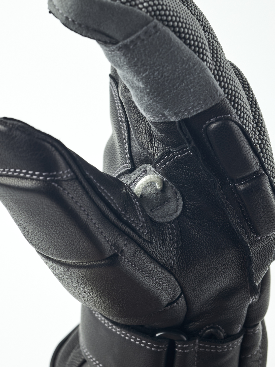 Schwarzer Lederhandschuh Nahaufnahme eines schwarzen Lederhandschuhs, der eine Hand darstellt. Details wie Nähte und Texturen sind sichtbar.