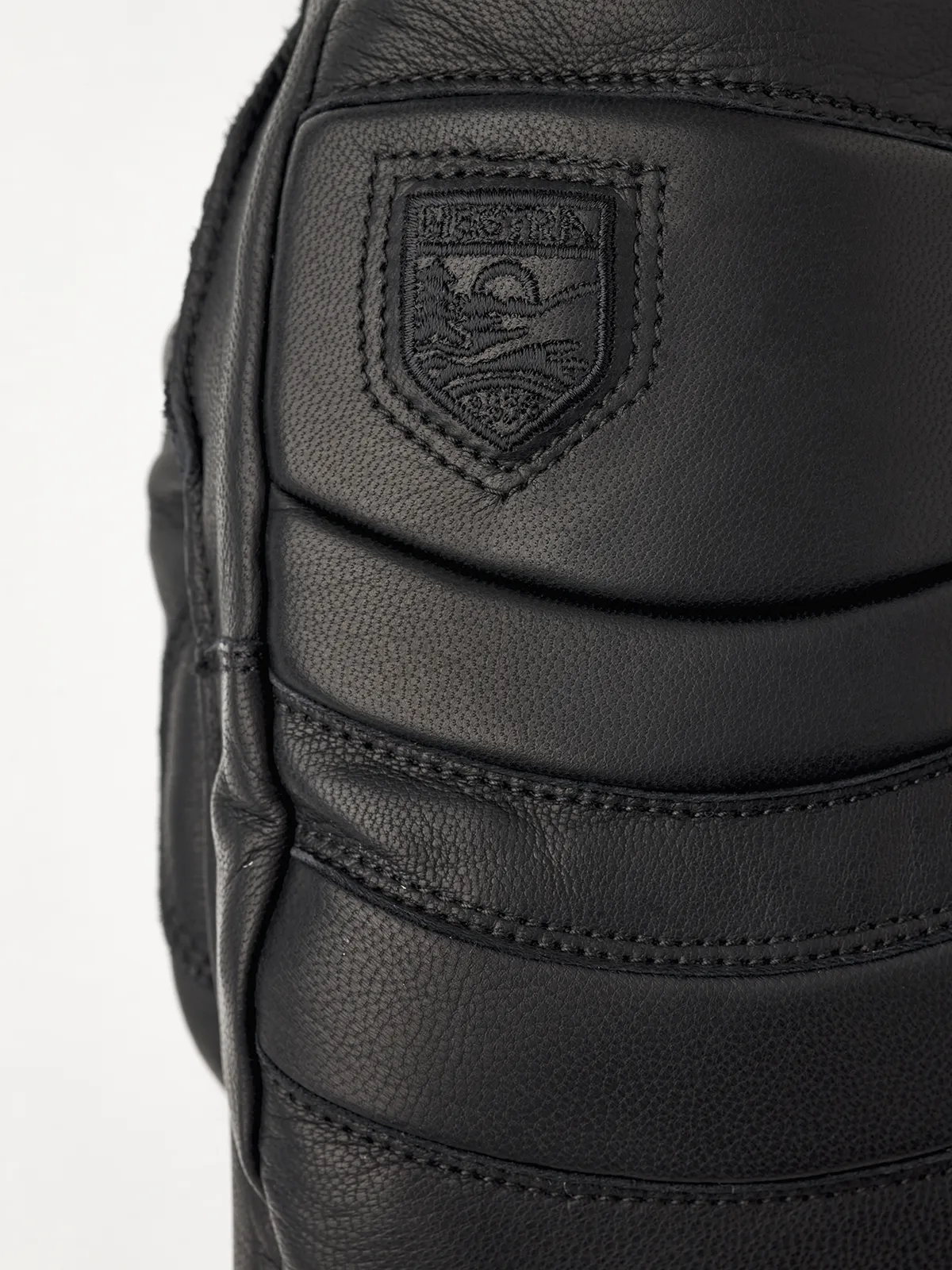 Detailaufnahme des schwarzen Hestra Fall Line Lederhandschuhs mit Logo.