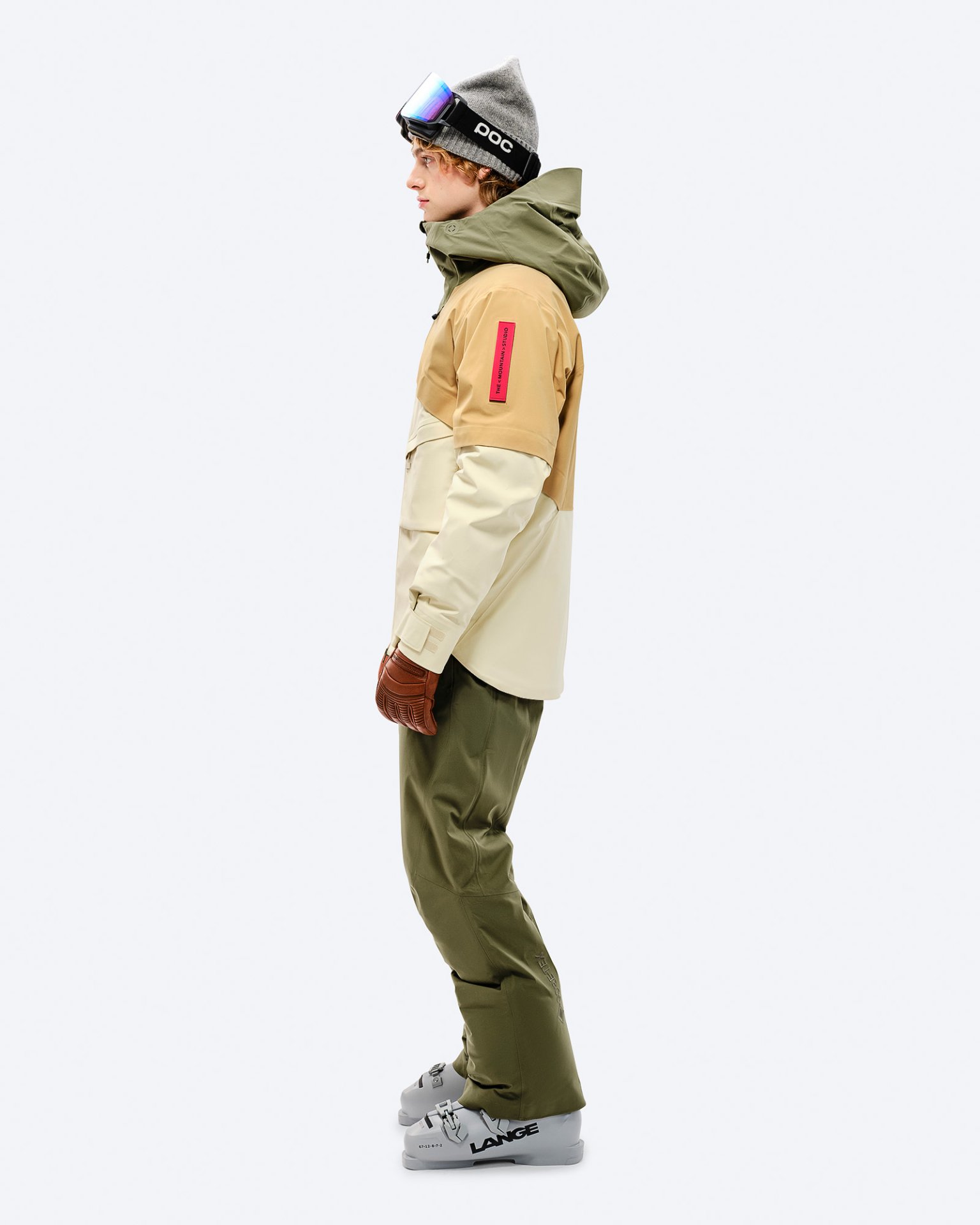 Mann in Winterausrüstung, Winter Moss Hose. Ski-Brille, Mütze und Skischuhe komplettieren den Look.