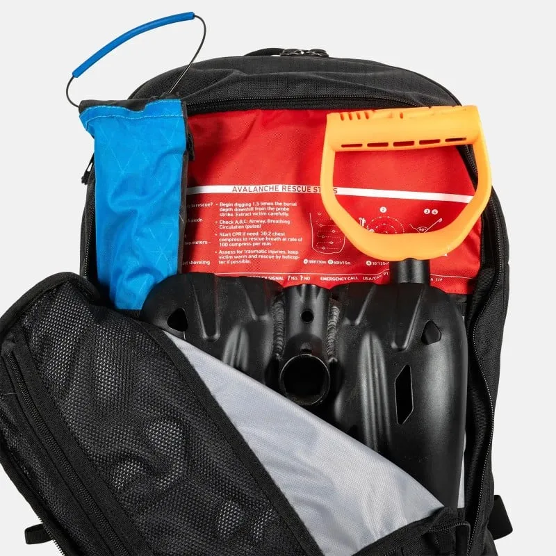 Offener Jones Further 25L Rucksack mit Lawinenschaufel, Sonde und Erste-Hilfe-Informationen in Rot. Fach mit Netzstruktur sichtbar.