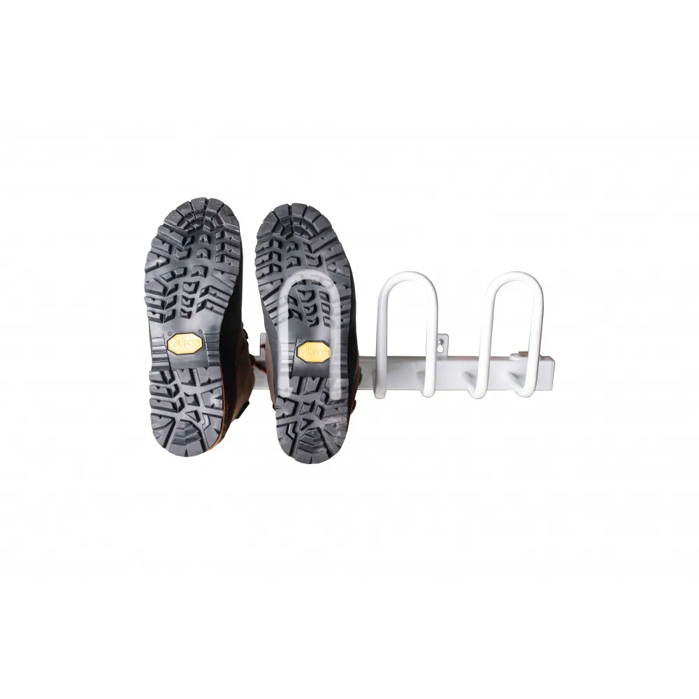 Ein Schuhregal mit zwei Wanderschuhen, die mit der Sohle nach oben hängen.