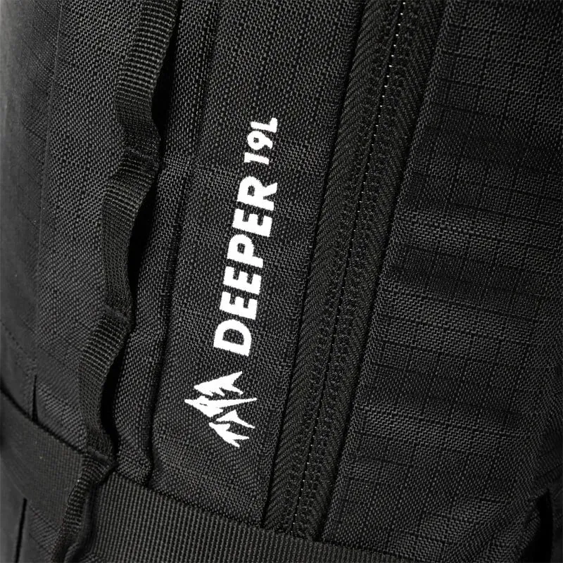 Detailaufnahme: Schwarzer Jones Deeper 19L Rucksack, Logo mit stilisiertem Berg und Reißverschluss.