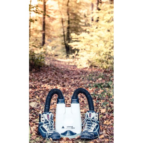 Alpenheat UniversalDry Schuhtrockner mit zwei Wanderschuhen im Herbstlaub vor einem Waldweg.