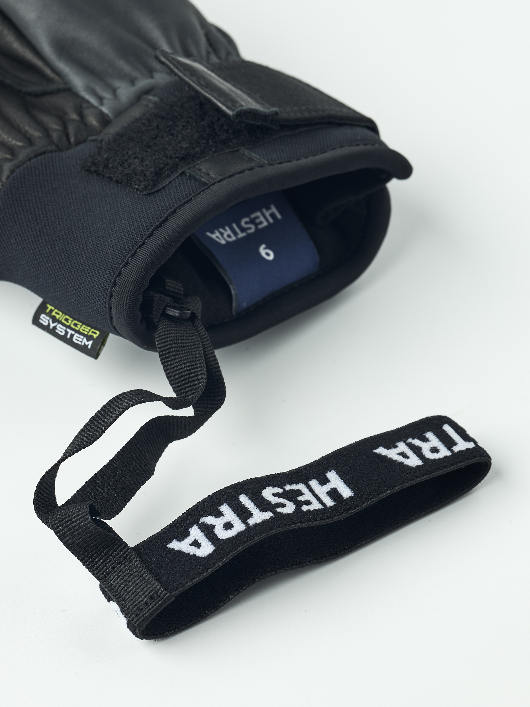 Schwarzer Hestra Omni Trigger Handschuh mit Schlaufe und Grössenangabe, Detailaufnahme.