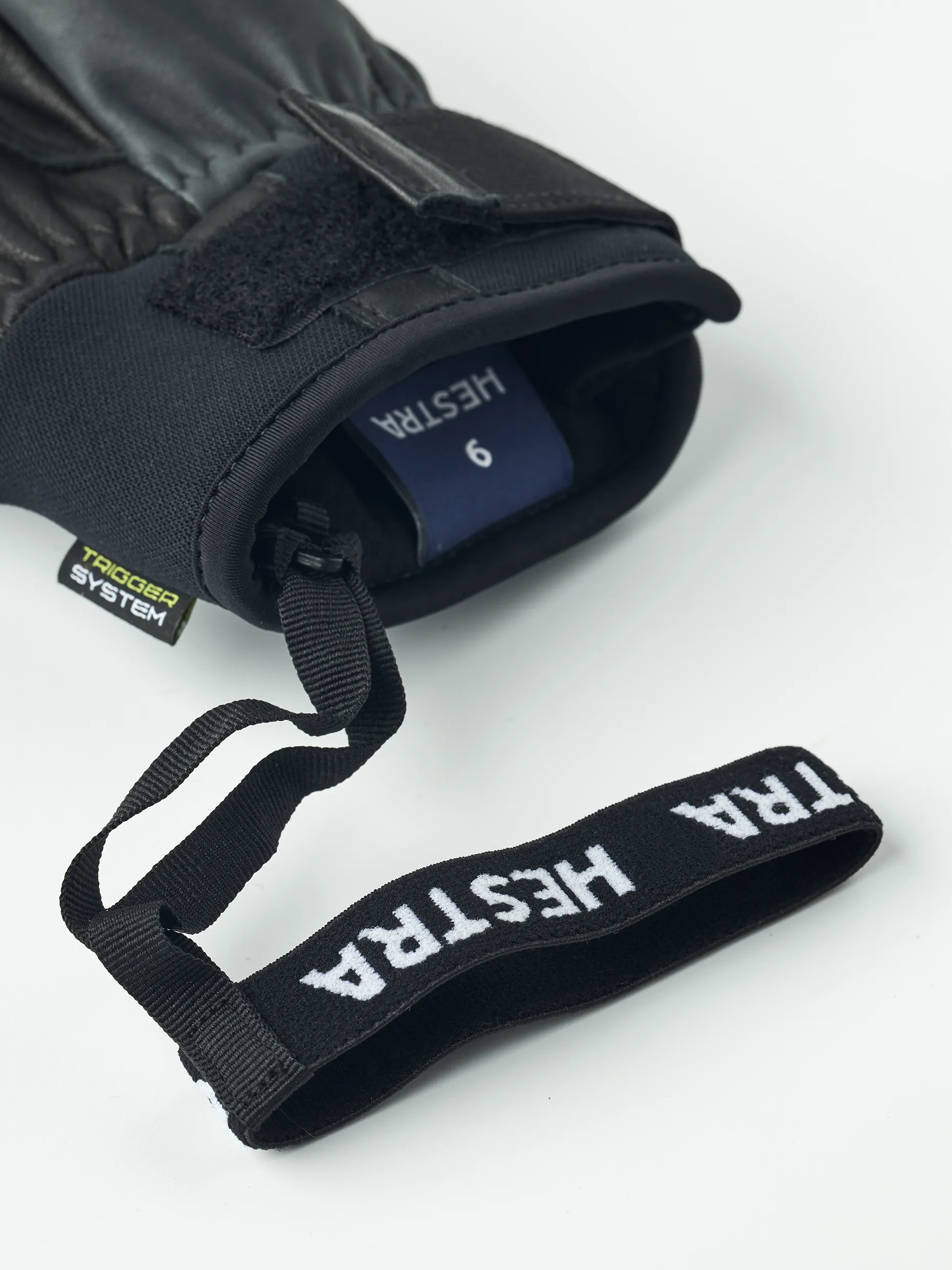 Schwarzer Hestra Omni Trigger Handschuh mit Schlaufe und Grössenangabe, Detailaufnahme.
