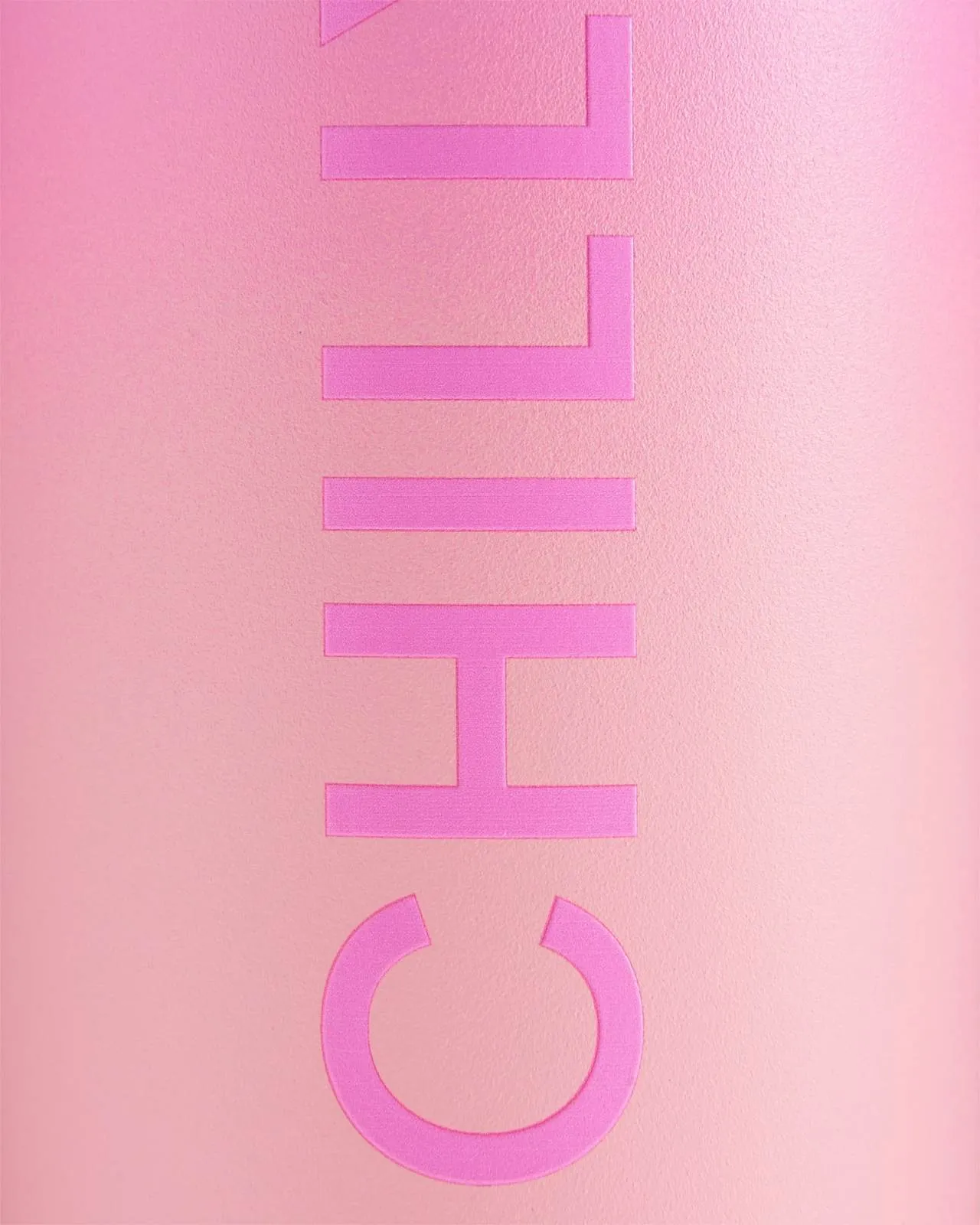 Nahaufnahme einer pinken Chillys Series 2 Flip Bottle mit erhabenem Logo auf pinkem Ombre-Hintergrund.