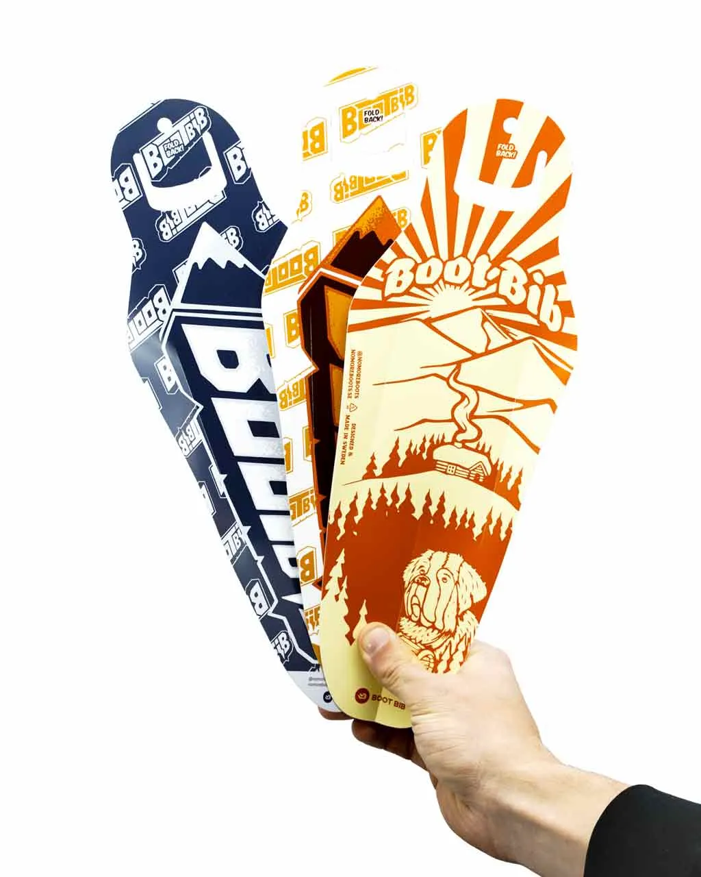 Hand hält drei Boot Bib Einlegesohlen mit unterschiedlichen Designs: Berge, Sonne, Hund.