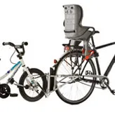 Tandemkupplung: Kinderfahrrad an Erwachsenenfahrrad gekoppelt. Am Erwachsenenfahrrad ist ein Kindersitz befestigt.
