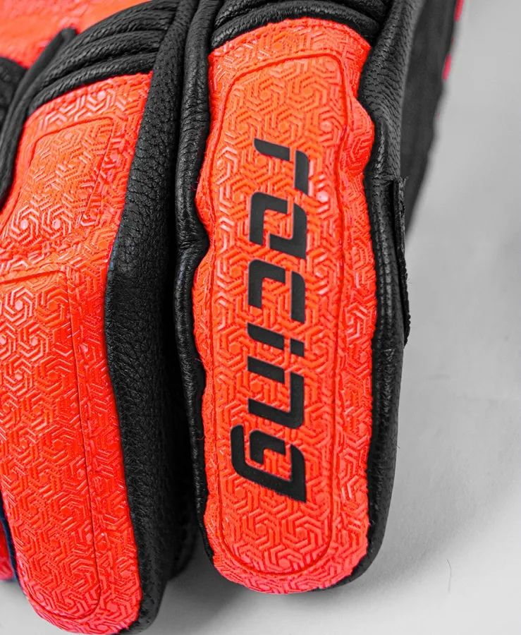 Detailaufnahme eines Motorradhandschuhs; Leder und orangefarbenes Material mit Muster und Schriftzug.