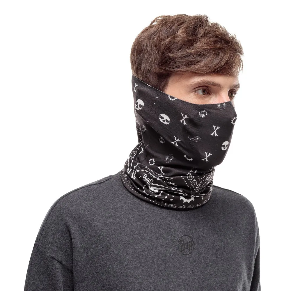 Mann trägt einen schwarzen Buff Filter Tube mit Totenkopfmuster und grauem Shirt.