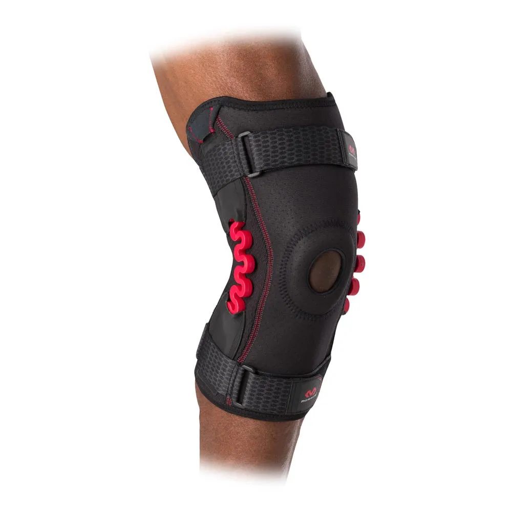Nahaufnahme einer schwarzen McDavid NRG Kniebandage mit roten Federn an einem Bein.