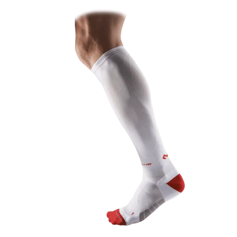 Weisse McDavid Compression Runner Socke am Bein, rot abgesetzt an Zehen und Ferse.