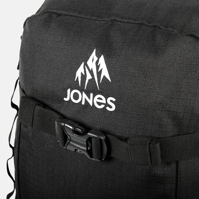 Detailaufnahme des schwarzen Jones Deeper 19L Backpack mit weißem Logo und schwarzem Gurtverschluss.
