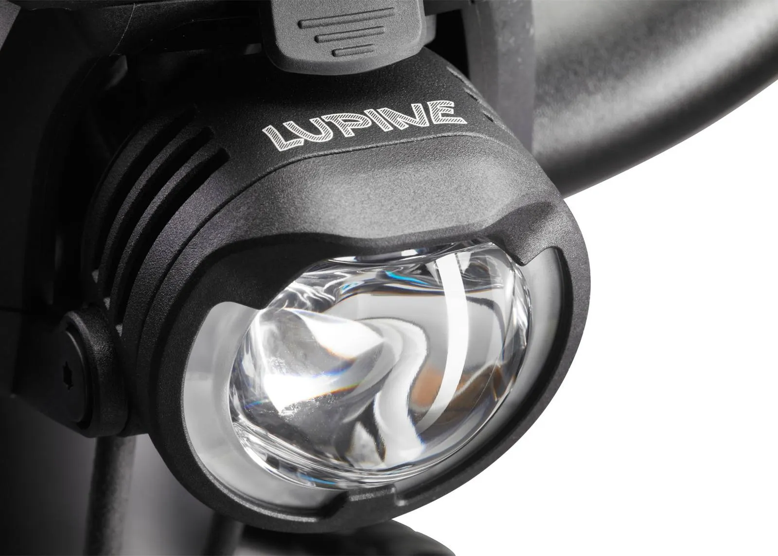 Nahaufnahme der Lupine SL B E-Bike Beleuchtung für Bosch, montiert an einem Fahrradlenker. Der Lampenkopf ist schwarz mit silbernem Lupine Logo.