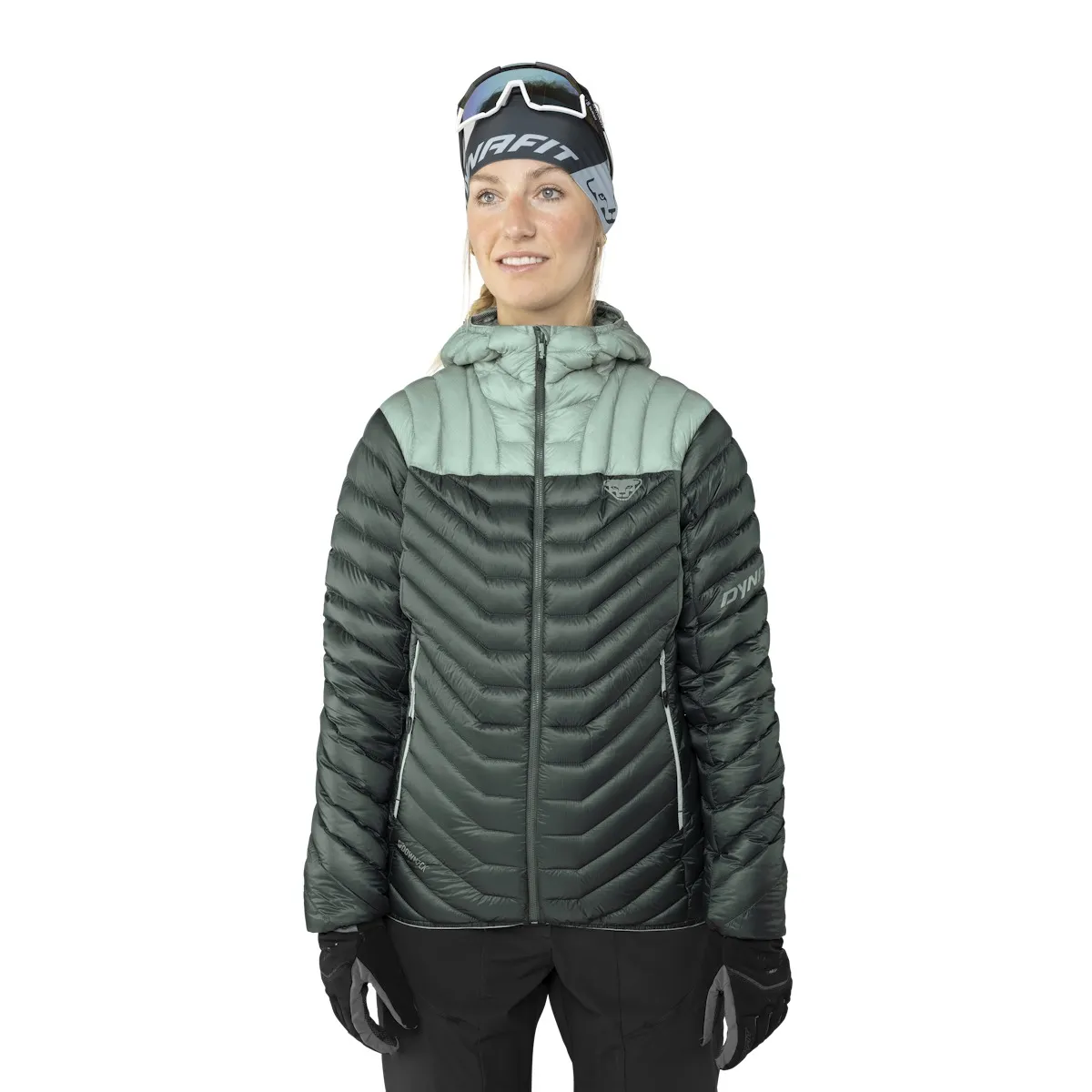 Frau in Daunenjacke mit Kapuze, grün und grau, trägt Stirnband und Handschuhe.