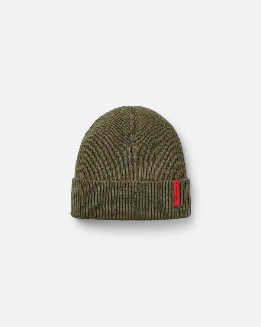 Grüne C-8 Cashmere Mix Rib Beanie mit rotem, vertikalem Logo-Etikett, isoliert auf weißem Hintergrund.