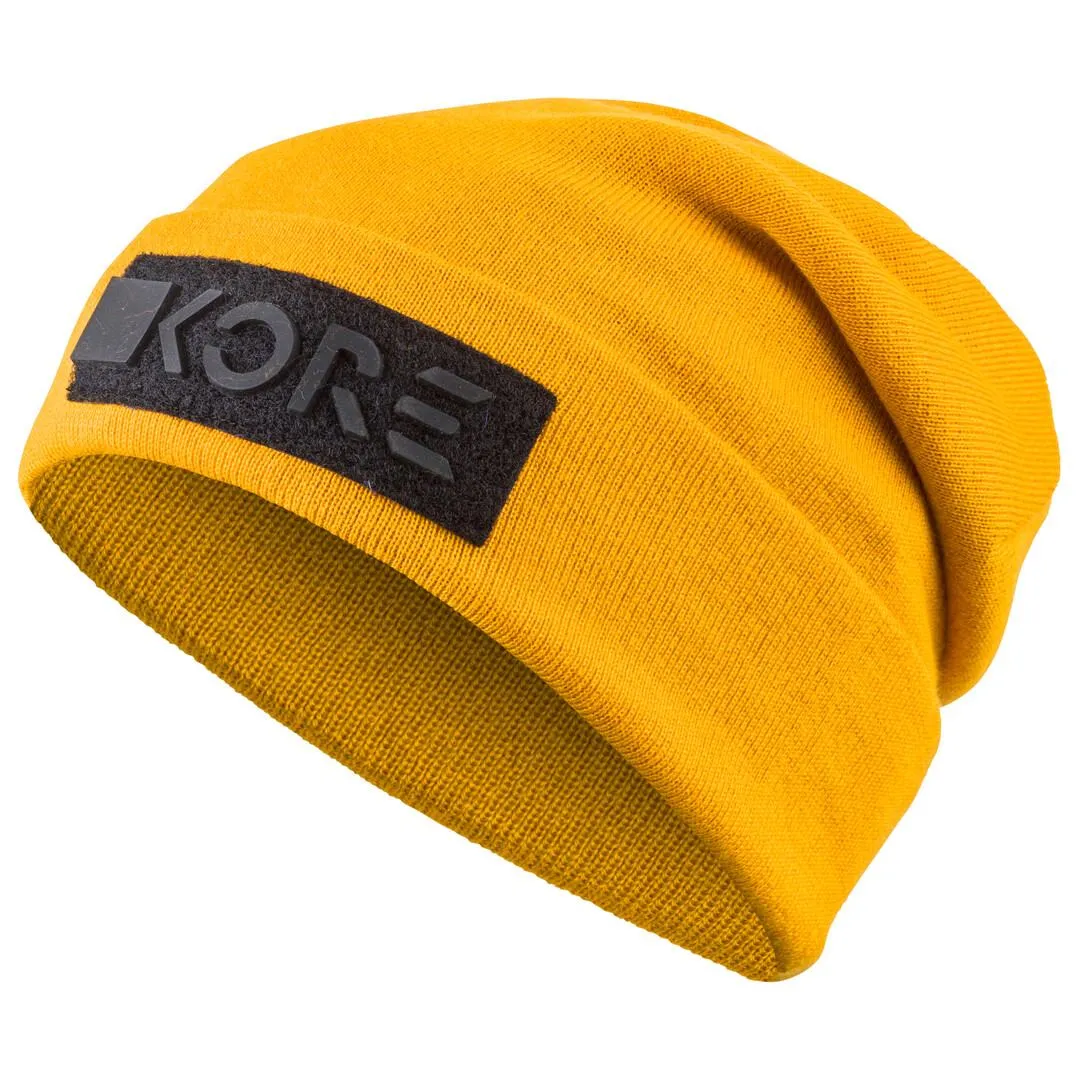 Gelbe KORE Beanie mit schwarzem Logo-Patch, gestrickt, auf weißem Grund.