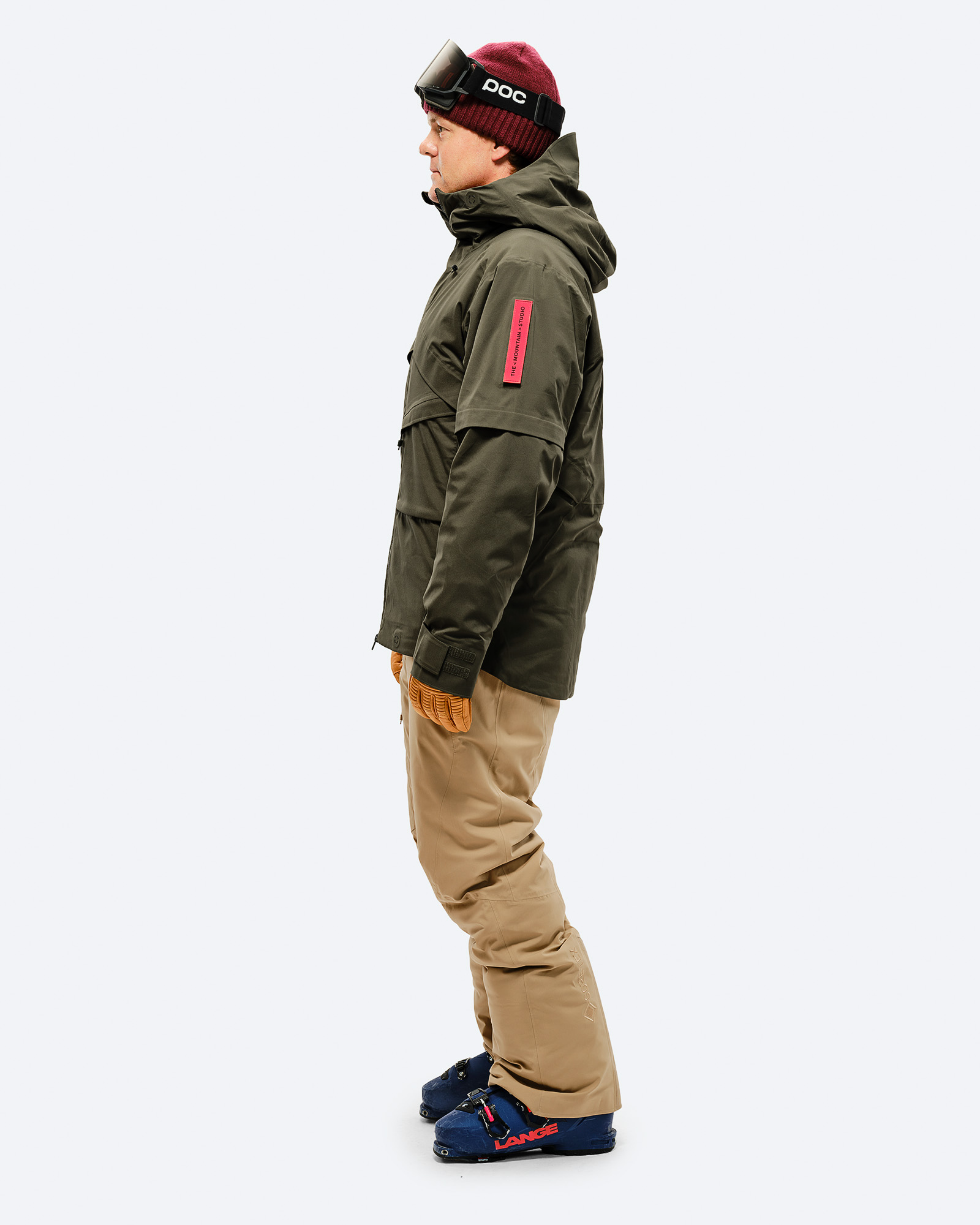 Person von der Seite in Ski-Outfit mit Sandfarbener GORE-TEX 2L Stretch Insulated Pant und Skischuhen.