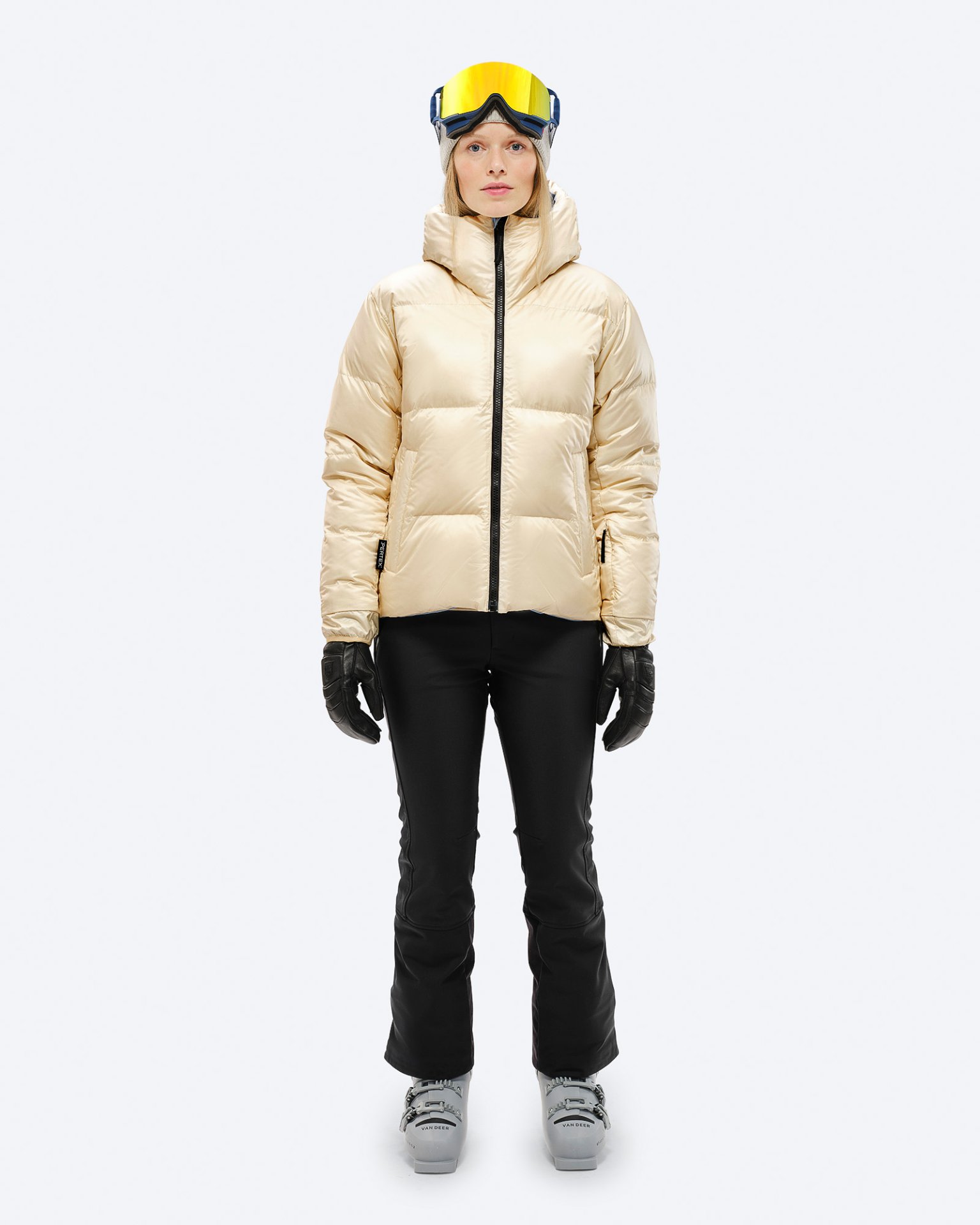 Person in Daunenjacke, Skihose, Skischuhe und Skibrille, Frontansicht, "Castle Wall" Farbe.