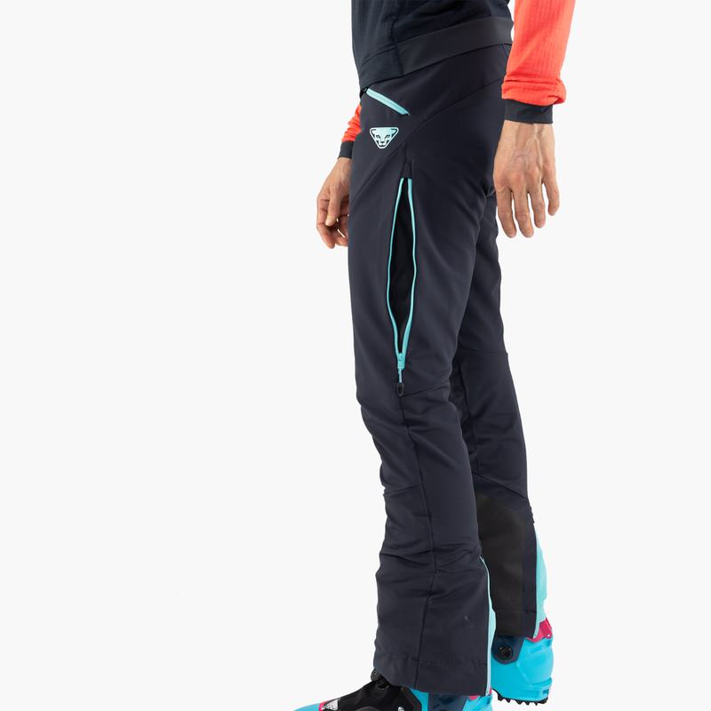 Detailansicht der Dynafit TLT Touring DST Women Hose in Blau, seitlicher Reißverschluss und Logo sichtbar.