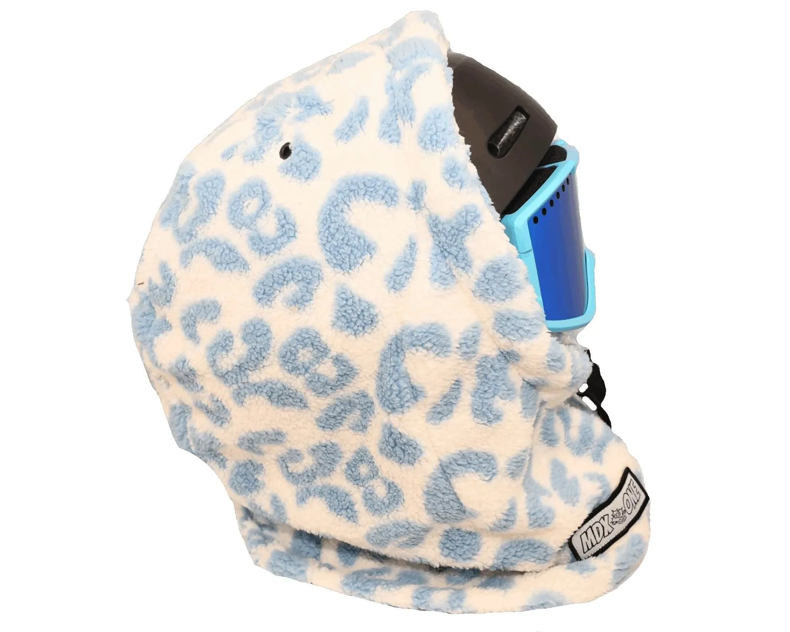 Eine flauschige, doppellagige Sturmhaube für Kinder in Cremeweiß mit hellblauen, fleckenartigen Giraffenmustern. Sie bedeckt einen dunklen Skihelm und blaue Skibrille. Die Balaclava schützt Kopf, Hals und Gesicht, ideal für kalte Wintertage.