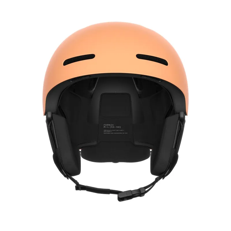 Pfirsichfarbener Skihelm von vorne, mit schwarzen Belüftungsschlitzen und Ohrpolstern. Kinnriemen sind unterhalb sichtbar.