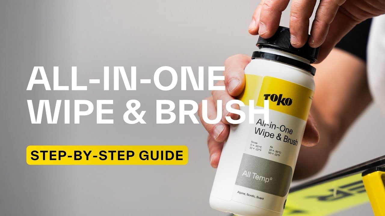 Eine Hand hält eine Flasche "Toko All-in-One Wipe & Brush". Auf der Flasche stehen Temperaturangaben für Schnee und Luft.