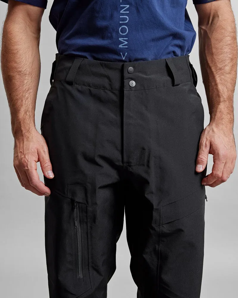Schwarze GORE-TEX Pro Shell Hose am Körper, Bund mit zwei Knöpfen, zwei Beintaschen mit Reißverschluss.