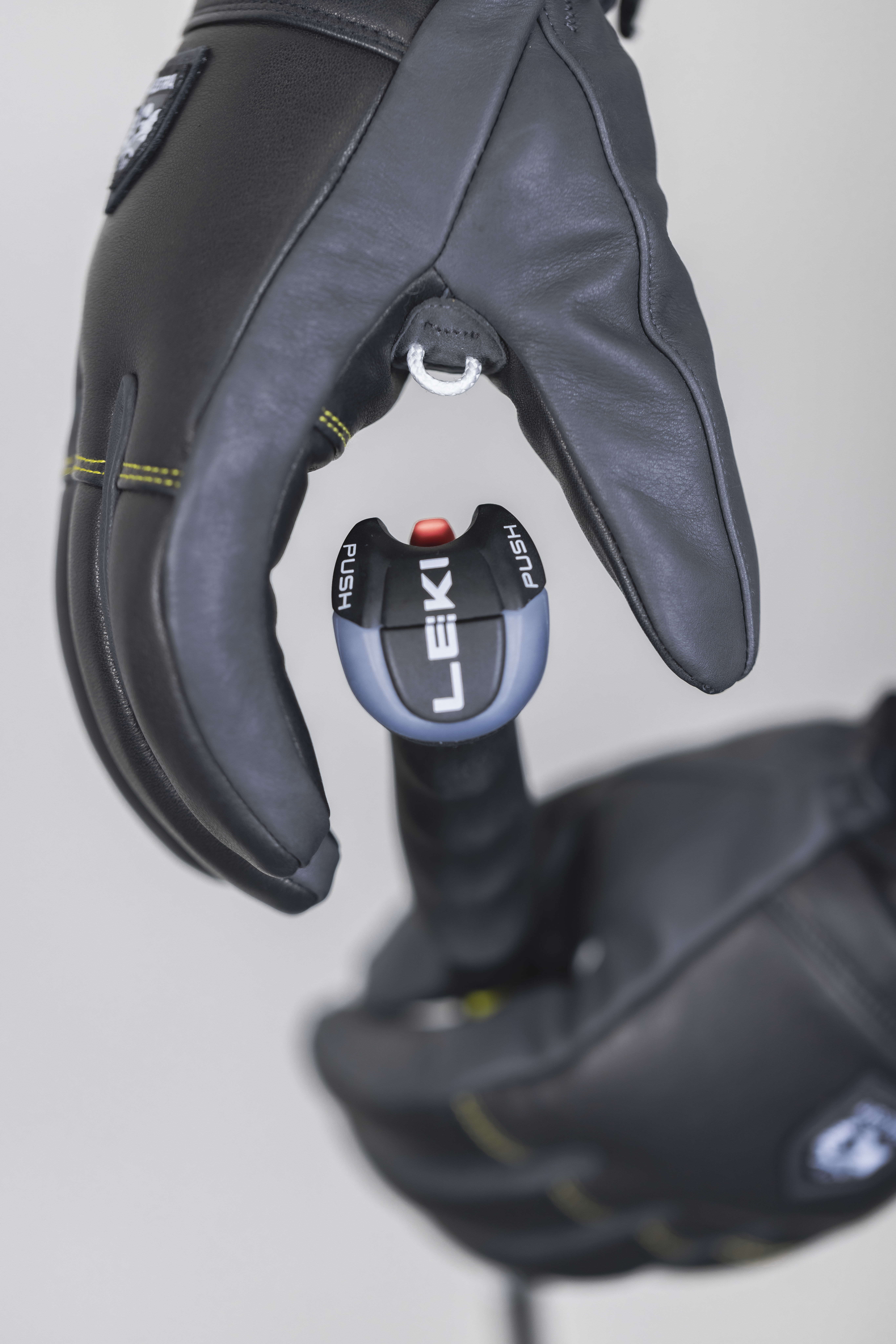 Schwarzer Hestra Omni Trigger Handschuh mit Leki Trigger System am Skistock befestigt. Detailaufnahme der Handschlaufe.
