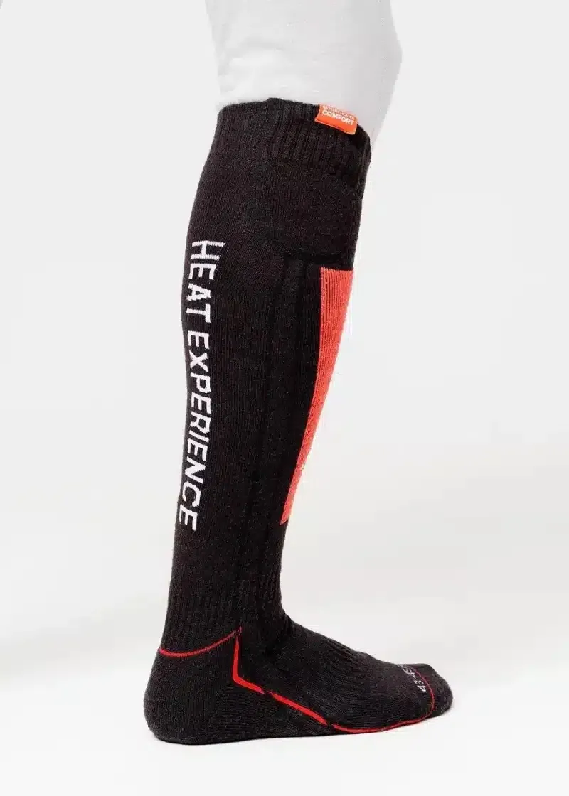 Eine lange, schwarze Socke mit "HEAT EXPERIENCE" in Weiß an der Seite, roter Akzentfarbe und einem kleinen orangen Etikett.