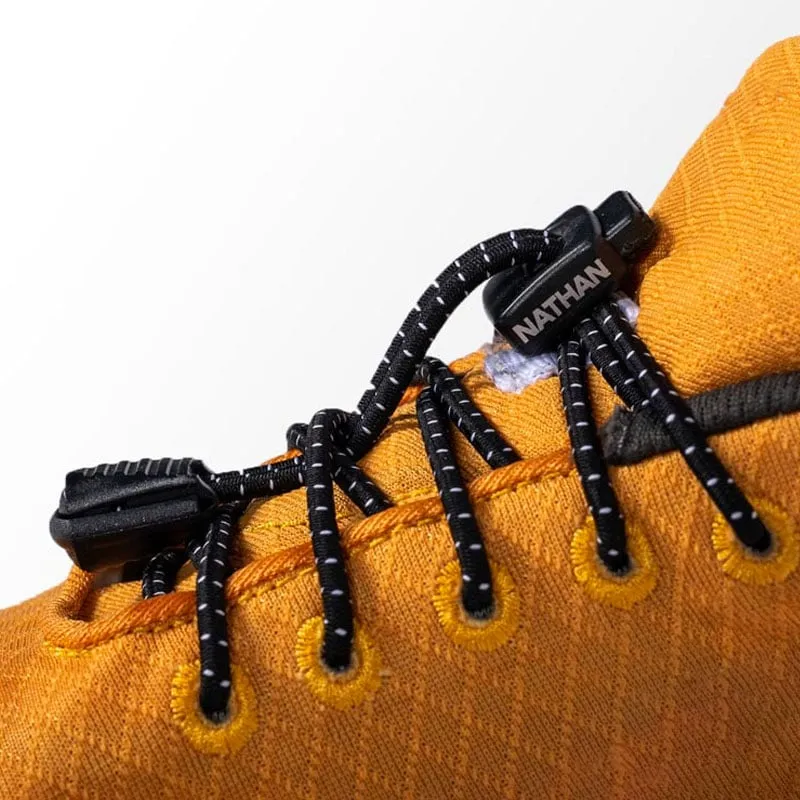 Detailansicht eines gelben Schuhs mit schwarzen Run Laces, die mit einem schwarzen Verschluss mit dem "Nathan"-Logo befestigt sind.