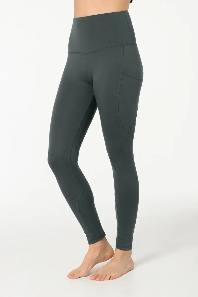 Graue Super.Natural Favourite Tights mit Seitentasche, an einer Person getragen, vor einem weißen Hintergrund.