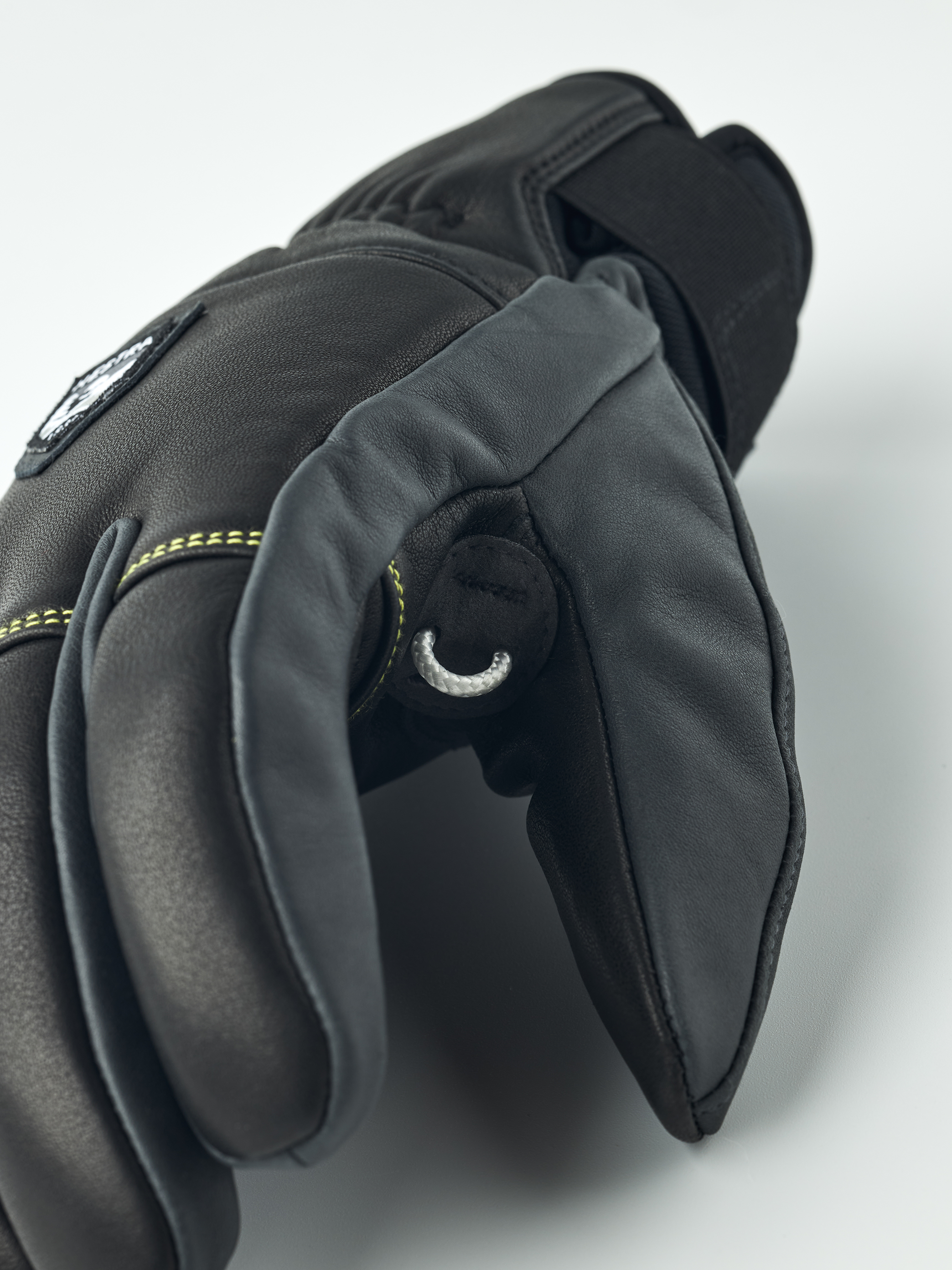 Nahaufnahme eines schwarzen Leder Hestra Omni Trigger Handschuhs mit Schlaufe, Fokus auf Finger.