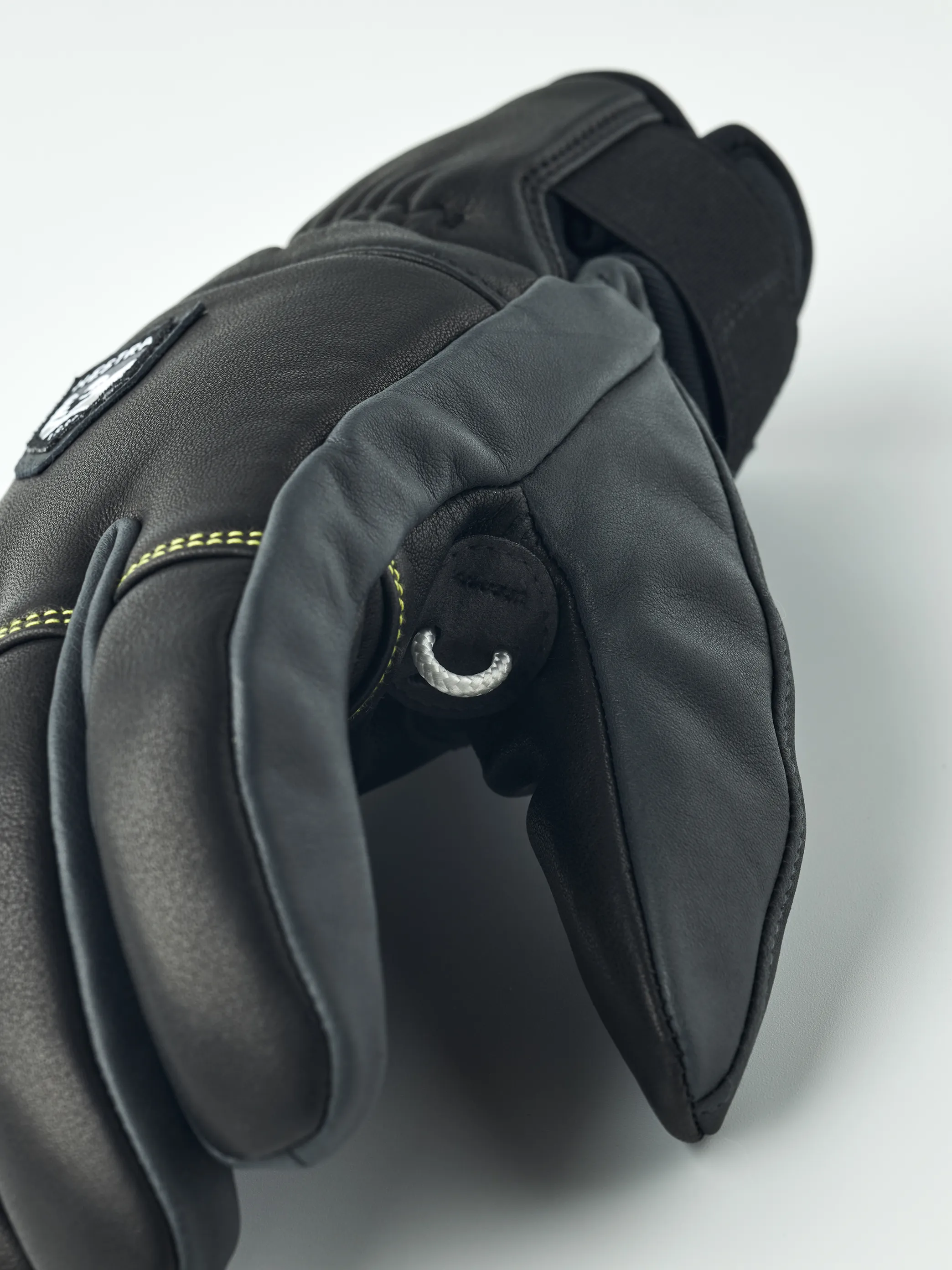 Nahaufnahme eines schwarzen Leder Hestra Omni Trigger Handschuhs mit Schlaufe, Fokus auf Finger.
