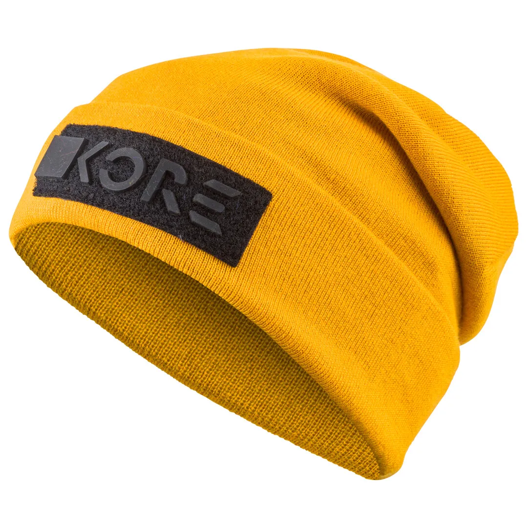 Gelbe KORE Beanie mit schwarzem Logo-Patch, gestrickt, auf weißem Grund.
