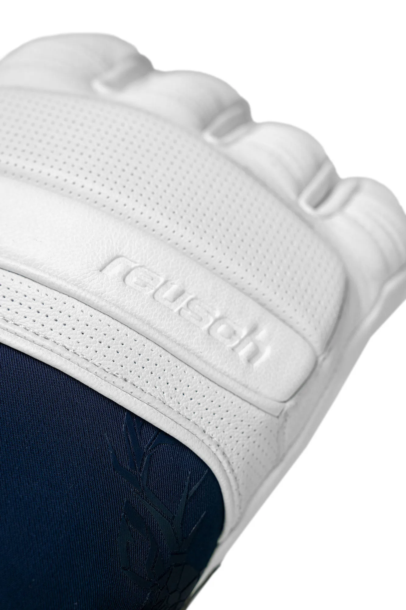 Nahaufnahme eines weißen Torwarthandschuhs mit "Reusch"-Logo und blauem Stoff darunter. Die Oberfläche ist mit kleinen Löchern versehen.