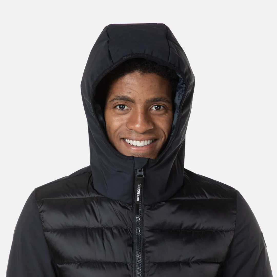 Porträt eines lächelnden Mannes mit schwarzer, gesteppter Rossignol Stretch Quilt Hoodie JKT Kapuzenjacke.