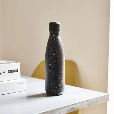 Schwarze Chillys Trinkflasche mit weißem Sprenkelmuster steht auf einem Tisch.