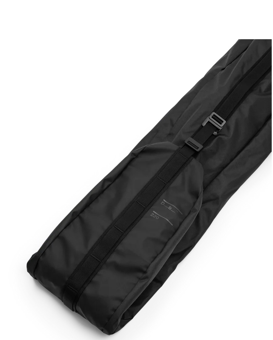 Schwarze Skitasche 220 Schwarze, gefüllte Douchbag Snow Essential Skitasche, diagonal im Bild, mit Tragegurt und „Db“- und „220“-Aufdruck.