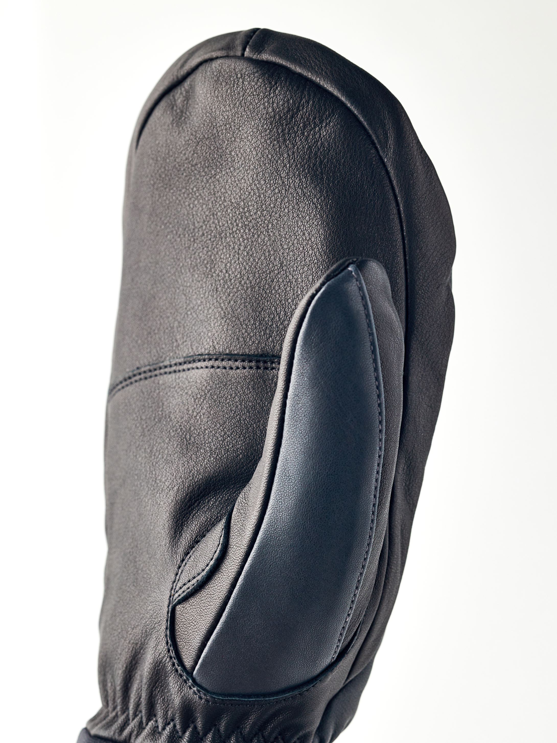Nahaufnahme eines schwarzen Lederhandschuhs, Army Leather Wool Terry Mitt, mit sichtbaren Nähten und Textur.
