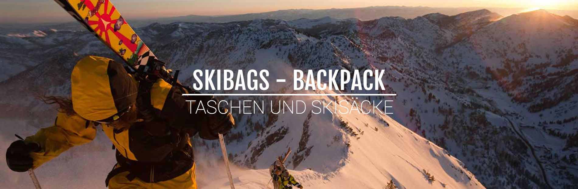 Person mit Skiern und Rucksack vor schneebedeckter Berglandschaft im goldenen Licht.